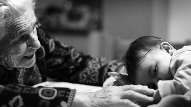 Elderly woman interacting with a toddler child